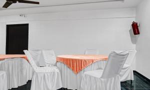 a table with white chairs and an orange table cloth at Itsy By Treebo - Banana Boutique Varuna Bridge Varanasi in Varanasi