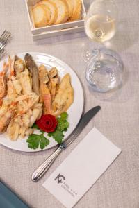 a plate of food on a table with a wine glass at Hotel Continental in Tortoreto Lido