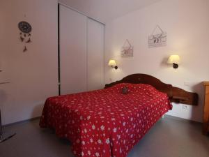 a bedroom with a bed with a red bedspread at Appartement Pelvoux, 2 pièces, 6 personnes - FR-1-330G-83 in Pelvoux