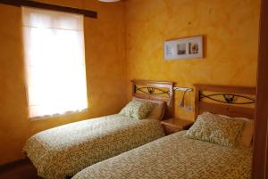 2 camas en una habitación pequeña con ventana en La formigana, en Soto y Amío