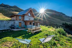 a house on a hill with a table and chairs at Le Refuge Ibex - Chalet d'Alpage au coeur de la nature - 8 personnes in Orcières