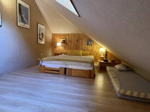a bedroom with a bed and a couch in a attic at Appartement Vallouise-La Casse, 2 pièces, 5 personnes - FR-1-330G-34 in Le Poët
