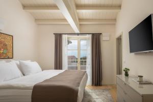 a bedroom with a bed and a tv and a window at Villa Florence by ILC-Istria Luxury Collection in Brtonigla +32 photos