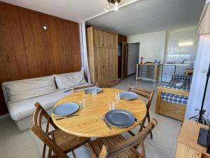 a dining room table with chairs and a kitchen at Appartement Puy Saint Vincent 1400, 1 pièce, 4 personnes - FR-1-330G-6 in Puy-Saint-Vincent