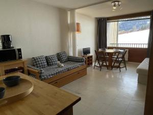 a living room with a couch and a table at Appartement Puy Saint Vincent 1400, 1 pièce, 4 personnes - FR-1-330G-6 in Puy-Saint-Vincent