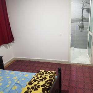 a bedroom with a shower and a bed in a room at Hotel camping amtoudi in Id AÃ¯ssa