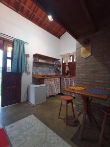 a kitchen with a table and a brick wall at Canto Ybykuara - Natural Guest House in Ibicoara