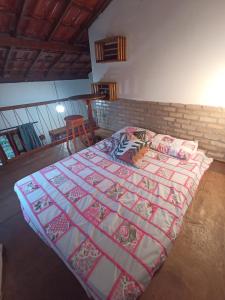 a bedroom with a bed with a quilt on it at Canto Ybykuara - Natural Guest House in Ibicoara