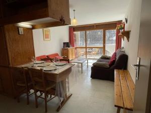 uma cozinha e sala de estar com uma mesa e um sofá em Appartement Puy Saint Vincent 1400, 2 pièces, 4 personnes - FR-1-330G-30 em Puy-Saint-Vincent