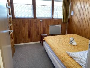 um quarto com uma cama com um cão sentado nela em Appartement Puy Saint Vincent 1400, 2 pièces, 4 personnes - FR-1-330G-30 em Puy-Saint-Vincent