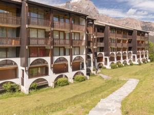 an apartment building in the mountains with a path in front at Appartement Puy Saint Vincent 1400, 2 pièces, 4 personnes - FR-1-330G-30 in Puy-Saint-Vincent