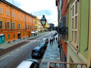 una calle con coches estacionados en el lateral de un edificio en Parizzi Suites & Restaurant en Parma