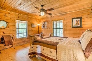 a bedroom with a bed in a log cabin at Cozy New Braunfels Family Cabin with Porch and Views! in New Braunfels