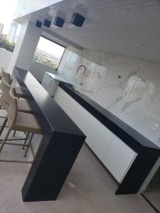 cocina con encimera y sillas en blanco y negro en Manaíra Apart Hotel 1505, en João Pessoa