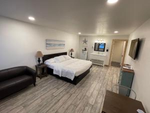 a bedroom with a bed and a couch and a television at The Inn at Old Town in Bandon