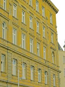 ウィーンにあるアパートメント ナーエ ゼントラムの窓が多い黄色の建物