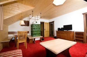 a living room with a table and a television at Alpenhäuser Marcius in Sonnenalpe Nassfeld