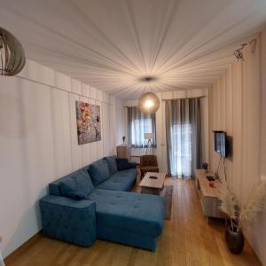 a living room with a blue couch and a table at Apartman Ana Alibi 1 in Zlatibor