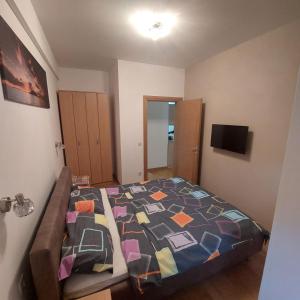 a bedroom with a bed with a colorful quilt at Apartman Ana Alibi 1 in Zlatibor