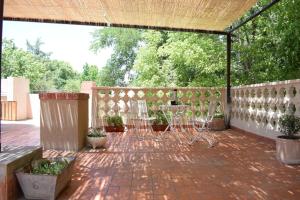 a patio with chairs and a fence and trees at Solaire Carrodilla in Ciudad Lujan de Cuyo