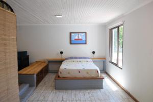 1 dormitorio con cama, mesa y ventana en Solaire Carrodilla en Luján de Cuyo
