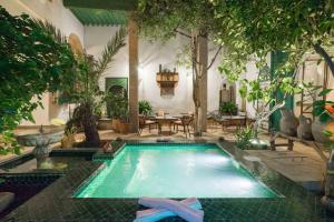 a swimming pool in the middle of a garden at Dar Kleta in Marrakesh