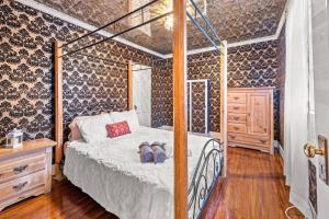 ein Schlafzimmer mit einem Himmelbett und einer Kommode in der Unterkunft Fully Restored Country Manor 