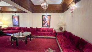 a living room with a red couch and a table at Flair's Family Apartment in Marrakech