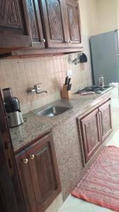 una cocina con fregadero y armarios de madera en Flair's Family Apartment, en Marrakech