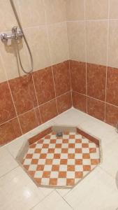 Flair's Family Apartment في مراكش: دش مع لوح شطرنج على الأرض في الحمام