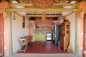 a kitchen with a table and a counter top at Casinha Caiçara in Ilhabela