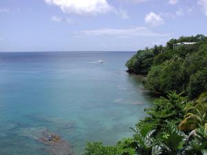 een boot in het water naast een strand bij Casa del Vega a Little Peace of Heaven in Castries