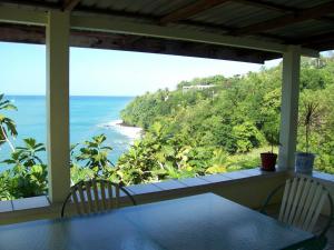 a view of the ocean from a porch with a table and chairs at Casa del Vega a Little Peace of Heaven in Castries