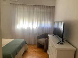 Dormitorio con cama y tocador con TV en Cálido departamento en Palermo en Buenos Aires