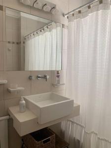 Baño blanco con lavabo y espejo en Cálido departamento en Palermo en Buenos Aires