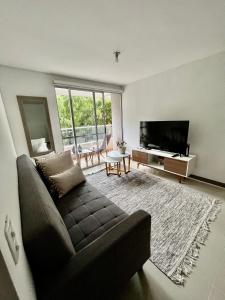 a living room with a couch and a flat screen tv at Sabaneta 22 in Sabaneta