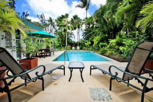 una piscina con 2 sillas y una mesa junto a una casa en Jessamine by Blue Sky Luxury, en Saint Peter