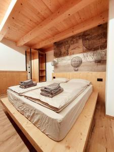 Cama grande en habitación con techo de madera en Appartamenti Zia Concetta, en Santo Stefano di Cadore
