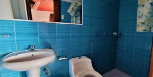 La salle de bains bleue est pourvue d'un lavabo et de toilettes. dans l'établissement VAGO HOSTEL, à Tingo María