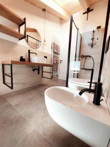 y baño con bañera blanca y lavamanos. en Appartamenti Zia Concetta, en Santo Stefano di Cadore