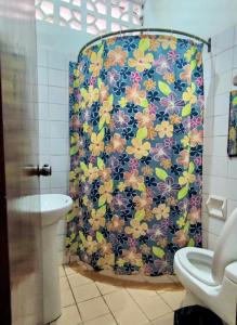 a bathroom with a shower with a floral shower curtain at VAGO HOSTEL in Tingo María