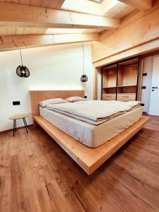 1 dormitorio con 1 cama grande y suelo de madera en Appartamenti Zia Concetta, en Santo Stefano di Cadore