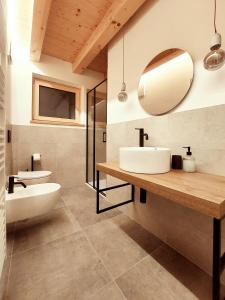y baño con lavabo blanco y espejo. en Appartamenti Zia Concetta, en Santo Stefano di Cadore