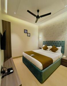 a bedroom with a bed and a ceiling fan at Hotel lime wood in Mumbai