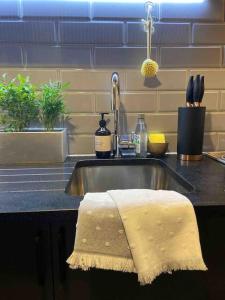 a kitchen sink with a towel on the counter at Spitalfields Market Penthouse Flat with balcony in London