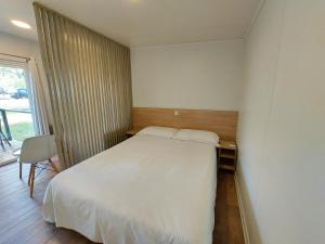 a bedroom with a large white bed and a window at Camping Osuna in Madrid