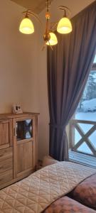 un dormitorio con una cama y una ventana en TatraTravel VILA unlimited golf for 2 person incl, en Veľká Lomnica
