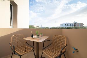 - Balcón con mesa pequeña y 2 sillas en Elegant Suite 2 near the Beach, en Ayía Marína