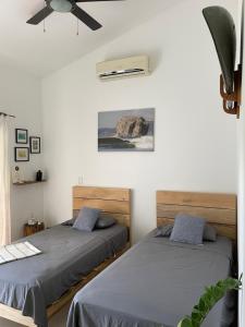 two beds in a room with white walls at El Chante Surf House in Santa Teresa Beach +54 photos