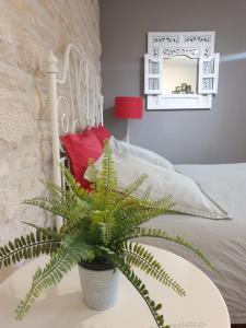 a plant sitting on a table next to a bed at Le Gîte Senlisien in Senlis
